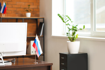 Wall Mural - Russian flag and computer on dark wooden table in office