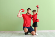 Little Boy With Boxing Trainer Near Green Wall
