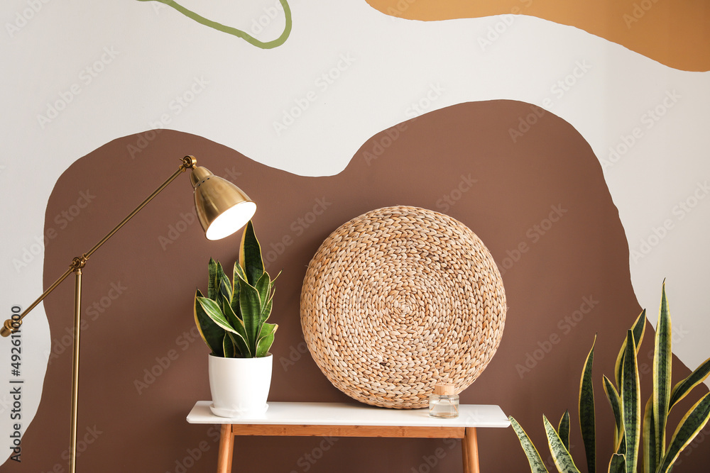 Interior of stylish room with golden standard lamp, table and pouf