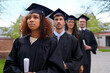 Higher education for high aspirations. Shot of graduating university students standing in a row looking up.