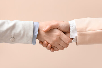 Wall Mural - Business colleagues shaking hands on beige background, closeup