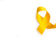 © Mercedes Fittipaldi - Lazo amarillo sobre un fondo blanco liso y aislado. Vista superior y de cerca. Copy space. Concepto: conciencia del cáncer