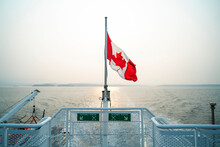 Canadian Flag Waves At Stern Of Ferry Boat Over Water