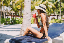 Woman Posing In A Bikini With A Cocktail On A Tropical Beach