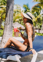 Woman Posing In A Bikini With A Cocktail On A Tropical Beach