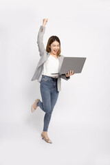 Wall Mural - Portrait of an excited Asian businesswoman holding laptop computer isolated on white background, Feeling happiness, Full body composition