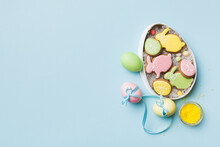 Colorful Easter Cookies In Basket With Multi Colors Easter Eggs On Colored Background . Pastel Color Easter Eggs. Holiday Concept With Copy Space