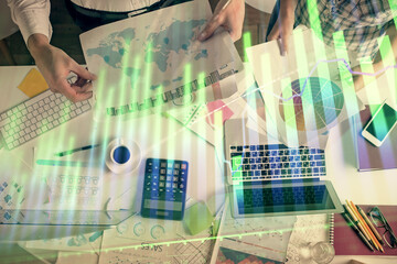 Double exposure of man and woman working together and financial chart hologram drawing. market analysis concept. Computer background. Top View.