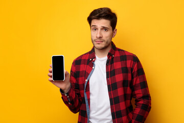Sad guy holding showing empty smartphone screen