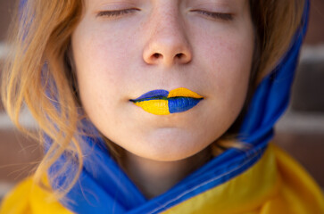 female face with closed eyes and painted yellow-blue lips close-up. National symbol of freedom and independence. Stop the war. Hope and Faith. Stand with Ukraine