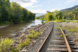 Abandoned, overgrown railroad train tracks along a rural river repurposed as trails for rail bikes in the Catskill Mountains of New York, USA