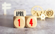 © Uladzislau - April 14th. April 14 wooden cube calendar with blur objects on background.