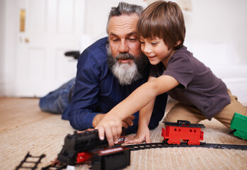 Sticker - Showing grandpa my new train set. Shot of a grandfather playing with toy trains with his grandson.