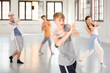 © JackF - Smiling teenage boy having group dance training in studio, performing dynamic elements