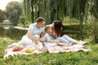 © hetmanstock2 - Happy family have a picnic in park near the lake