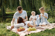 © hetmanstock2 - Happy family have a picnic in park near the lake