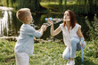 © hetmanstock2 - Young mother resting with her son in a park and blowing a soap bubbles