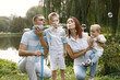 © hetmanstock2 - Happy family blowing a soap bubbles in park near the lake