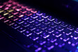 Neon computer keyboard with color backlight. Computer video games, hacking, technology, internet concept. Selected focus.