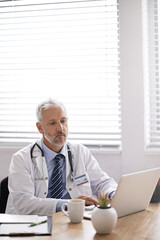 Aufkleber - Typing out some medical reports. Cropped shot of a mature male doctor working at his desk.