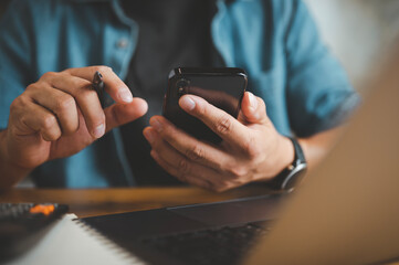casual businessman working using mobile phone typing computer mobile chat laptop contact us at workp