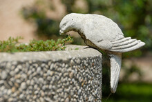 A Stone Sculpture Of A White Bird