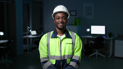 Portrait of smiling African-American engineer in hardhat smiling at camera