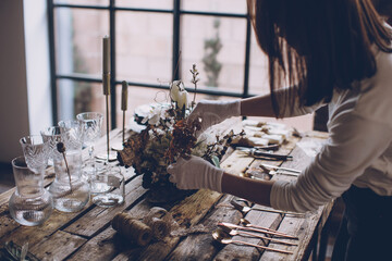 Table setting. A woman decorates the table for the holiday. High quality photo