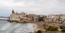 Panoramic Of Sitges Town Located Southwest Of Barcelona. Touristic And Cultural Village Known For Its Beaches, Nightspots, And History. Cloudy Coastline With Charming And Picturesque Buildings.