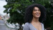 © Marco - A happy Brazilian woman standing outside in urban street
