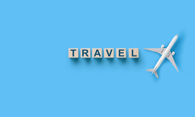 Wall Mural - traveling concept , wooden cubes with travel word and toy airplane