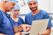 © Robert Kneschke - Ärzteteam mit Laptop Computer bei der OP Planung