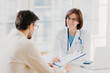 © VK Studio - Doctor consults patient, shows information and prescription in clipboard, talk about medical checkup