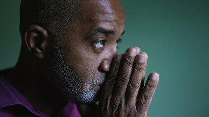 A south american senior black man praying to God