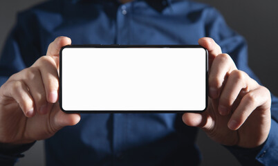 Wall Mural - male hands holding a smartphone with blank screen.
