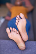 © Meeko Media - A close up shot of bare feet while a woman naps on the sofa