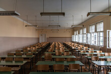 Empty Old Faculty Or College School Classroom With Row Of Chairs, Green Desk Tables And Big White Windows. Natural Light.
