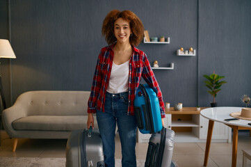 Wall Mural - Smiling woman holding baggage in living room