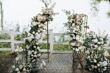 Poster - Beautiful wedding arch of fresh flowers by the lake. Decor for a wedding ceremony