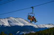 Active sporty lifestyle and winter vacation at Breckenridge Ski Resort in Colorado. People riding chairlift to the peak of the mountain on a beautiful sunny day.