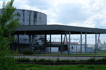 Wall Mural - FU 2021-05-13 Rheinhafen 291 Unter leicht bewölktem Himmel ist eine Industrieanlage