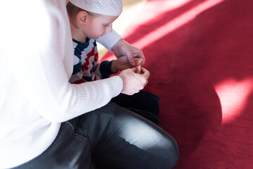 Ramadan Kareem greeting. Father and son in mosque. Muslim family praying