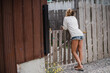 © Jarusha Brown/Stocksy - Woman leans on wooden gate.