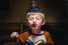 A Little Boy Eats A Marshmallow With Chocolate Fondue.