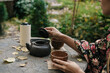© Dreamwood videography - Mikhail Nilov/Stocksy - A young woman pours tea into a cup in the garden