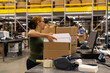 © Raymond Forbes LLC/Stocksy - Retail worker ships order in box at ecommerce warehouse