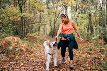 A Beautiful Woman Has Fun With Her Dog In Autumn