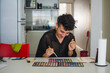 © Ana Luz Crespi/Stocksy - Happy gender queer person with make up palette