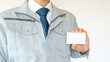 作業服の男性・建設業イメージ｜空白の名刺、ビジネスカードを持つ