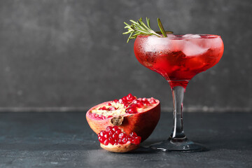 Wall Mural - Glass of tasty pomegranate cocktail on black background